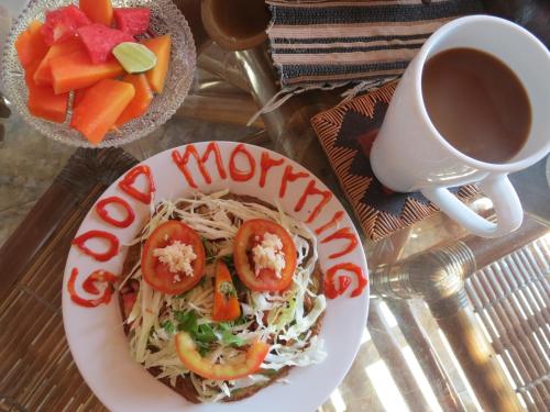 un plato de espaguetis con tomates y una taza de café en Lemon House, en Padangbai