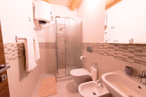 łazienka z toaletą, umywalką i prysznicem w obiekcie Aura Ortigia Apartments w Syrakuzach