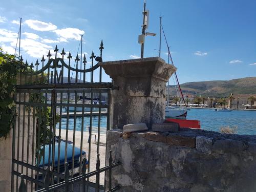 a gate with a cross on it next to a body of water at Room Cvita in Trogir
