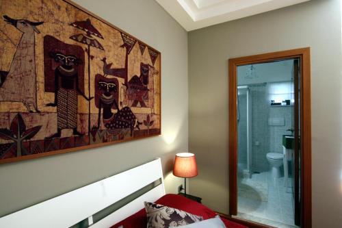 カゼルタにあるResidenza D'Epoca B&B Celesteのベッドルーム1室(ベッドの上に絵画、鏡付)