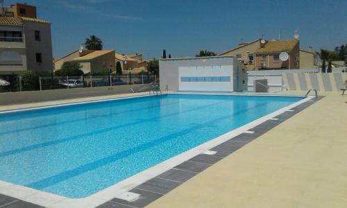 a large blue swimming pool in a apartment at Port Soleil - Naturist Village in Cap d'Agde