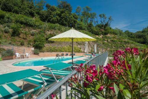 uma piscina com guarda-sol e flores roxas em Gli Ulivi Di Montalbano em La Spezia