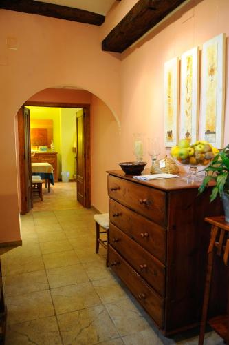 a kitchen with a wooden dresser with a bowl of fruit on it at Font del Pas in Beceite