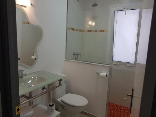 a white bathroom with a toilet and a sink at Las Belisas in Arenal d'en Castell