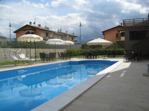 a swimming pool with tables and chairs and umbrellas at Hotel Natura in Castel di Sangro