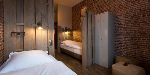 a bedroom with two beds and a brick wall at Heimathafen Hostel in Lörrach