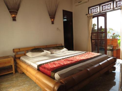 1 dormitorio con 1 cama grande con marco de madera en Lemon House, en Padangbai