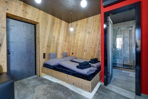 ein Schlafzimmer mit einem Bett in einer Holzwand in der Unterkunft Apartmány ELISA in Šumperk