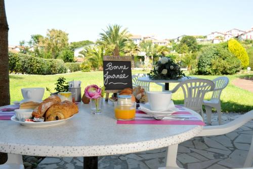 a table with a breakfast of croissants and orange juice at Hotel & Appartements Gochoki in Bidart