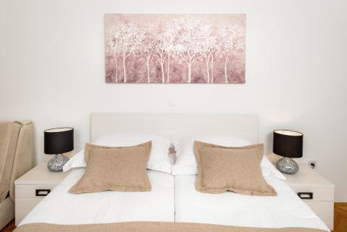 a bedroom with a white bed with two lamps at B&B Aurora in Jelsa