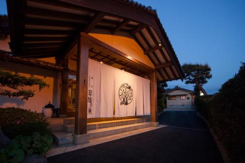 a building with a lit up sign on the side of it at Onsen Guest House Aobato no Su in Matsue