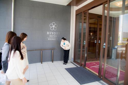 a woman standing in front of a building at Hiyori Hotel Maihama in Urayasu