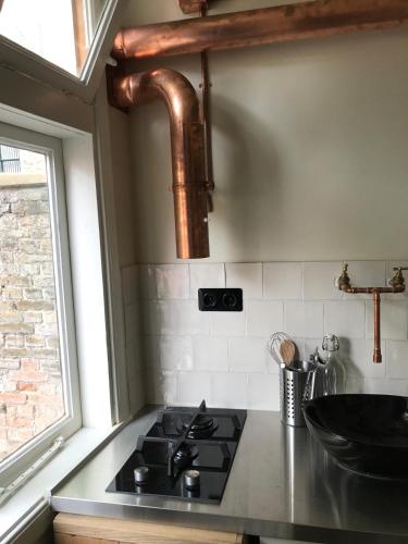 a kitchen with a stove top and a window at bednextdoor in Middelburg