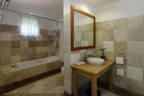 ein Badezimmer mit einem Waschbecken, einer Badewanne und einem Waschbecken in der Unterkunft Villa in Blue in Dauin