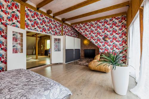 1 dormitorio con papel pintado de flores rojas y maceta en Villa Bach, en Valgeranna