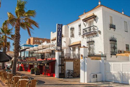 a white building with a hotel sign on a street at Hotel Playa de Regla in Chipiona