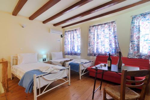 a room with two beds and a couch and a table at Studio Milo in Corfu