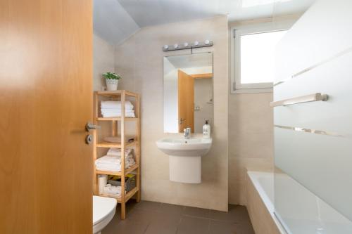 y baño con lavabo, aseo y espejo. en Apartamentos Cornellalux 2, en Cornellà de Llobregat