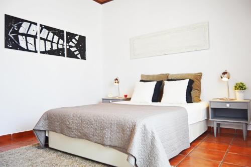 a white bedroom with a bed and two night stands at Belém Apartment in Lisbon