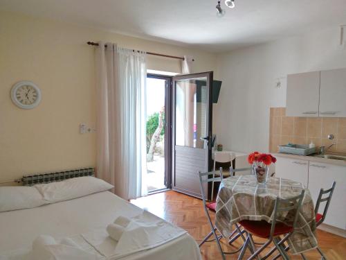 a room with a table and a kitchen with a table and a tableablish at Family Apartments K&M in Pag