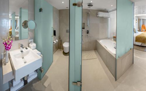 a bathroom with a sink and a tub and a toilet at The Taj Mahal Tower, Mumbai in Mumbai
