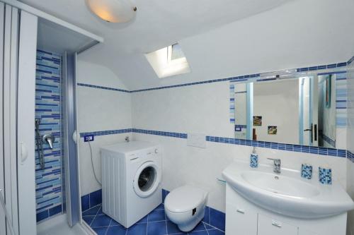 a blue and white bathroom with a toilet and a sink at BB Ravello Houses in Ravello