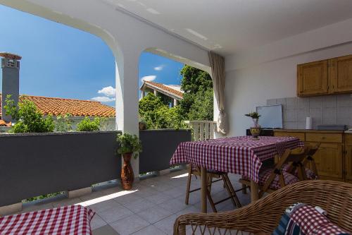 een keuken met een tafel en stoelen op een balkon bij Villa Mađor in Makarska