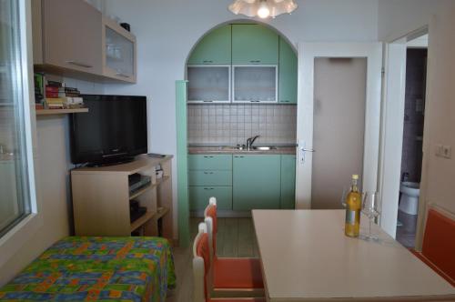 una pequeña cocina con mesa y TV en Apartment Toncica, en Omiš
