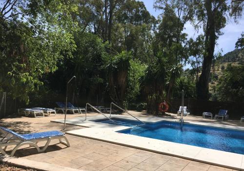 a swimming pool in a yard with a chair at Hotel del Balneario in Tolox