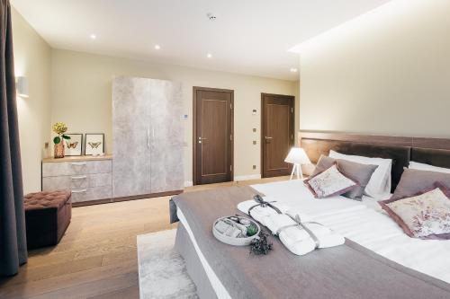 a large bedroom with a large bed with white sheets at Sala Resort Plateliai & SPA in Plateliai