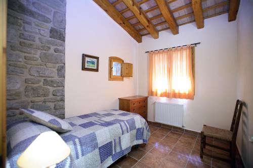 a bedroom with a bed and a stone wall at Entre Roures in Moià
