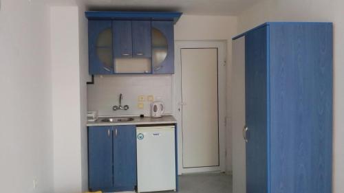 ツァレヴォにあるApartment 4のキッチン(青いキャビネット、白い冷蔵庫付)