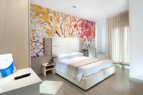 a bedroom with a large bed and a colorful painting at Hotel Europa in Cupra Marittima