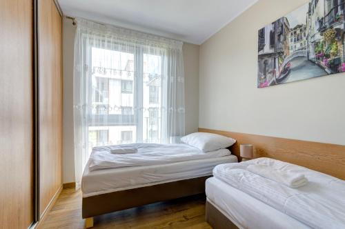 um quarto com 2 camas e uma janela em Sun&Sea - Tremare Residence em Gdansk