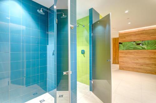 uma cabina de duche em vidro numa casa de banho com azulejos azuis em Sun&Sea - Tremare Residence em Gdansk