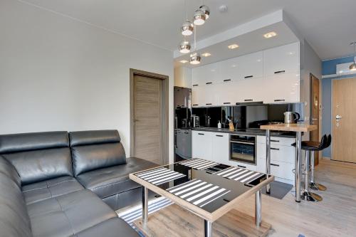 a living room with a couch and a table at INA Rent - Tre Mare Apartamenty in Gdańsk