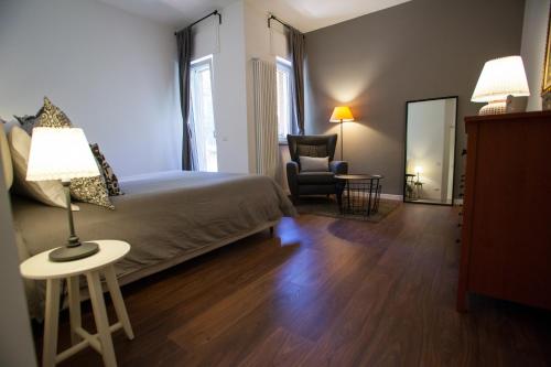 1 dormitorio con 1 cama, 1 silla y 1 lámpara en Oikos en Matera