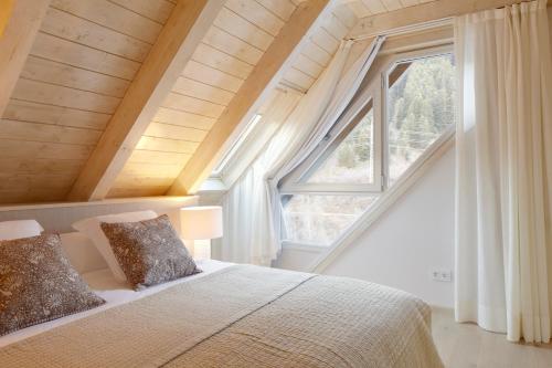 a bedroom with a bed and a large window at Val de Ruda Luxe 50 by FeelFree Rentals in Baqueira-Beret