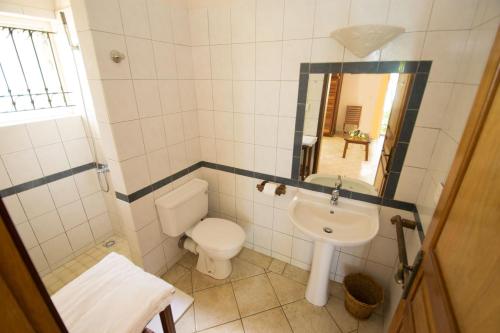 a small bathroom with a toilet and a sink at Residence Peramal in Grand Baie