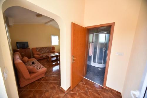 ein Wohnzimmer mit einem Sofa und einem Tisch in der Unterkunft Apartmani Stanisic in Čanj