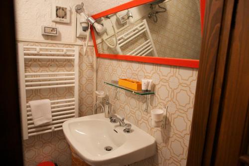 a small bathroom with a sink and a mirror at Appartamento Le Violette in Dolceacqua