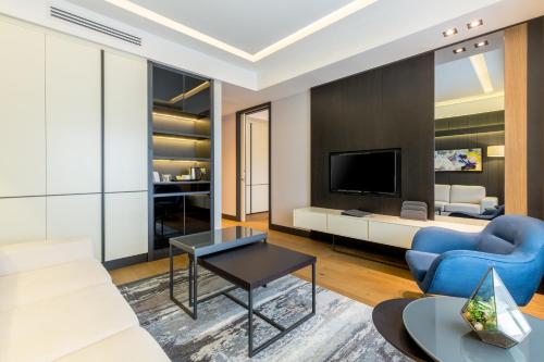 a living room with a blue couch and a tv at The Fortyfive Business Hotel & Spa in Manisa