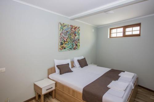 a bedroom with a large bed with a painting on the wall at Apartments St Dimitrij in Ohrid