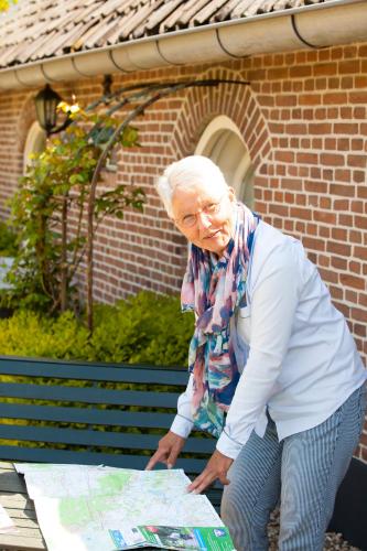 an older woman is looking at a map at Bed and Breakfast Klein Groenbergen in Leersum