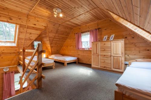 a bedroom in a log cabin with two beds at Adria Domki in Pobierowo