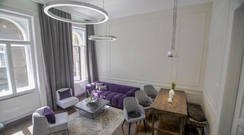 ブダペストにあるOpera Apartment with FREE parking, 2BR2BA, ACの紫色のソファと椅子が備わるリビングルーム
