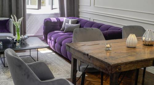 ブダペストにあるOpera Apartment with FREE parking, 2BR2BA, ACの紫色のソファとテーブル付きのリビングルーム