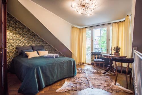 een slaapkamer met een bed, een tafel en een trap bij Karja Castle Apartments in Haapsalu