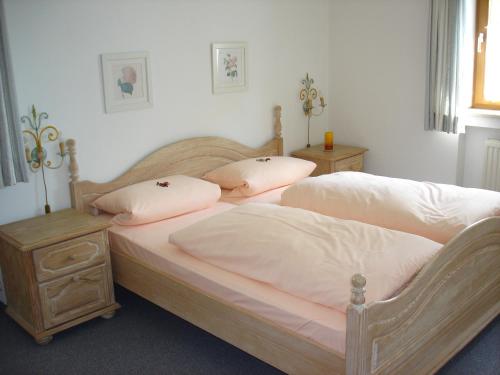 2 Betten mit weißer Bettwäsche und Kissen im Schlafzimmer in der Unterkunft Ferienwohnanlage Partnach in Garmisch-Partenkirchen
