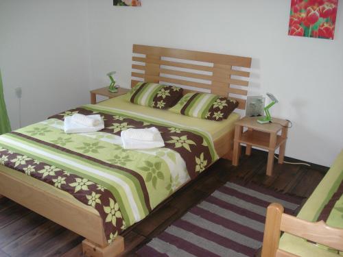 a bedroom with a bed with green and brown sheets at Apartment Gradina in Korenica